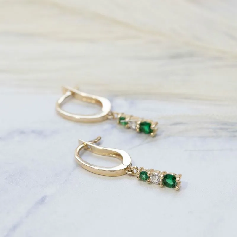 Yellow gold dangling earring with green and white zircons